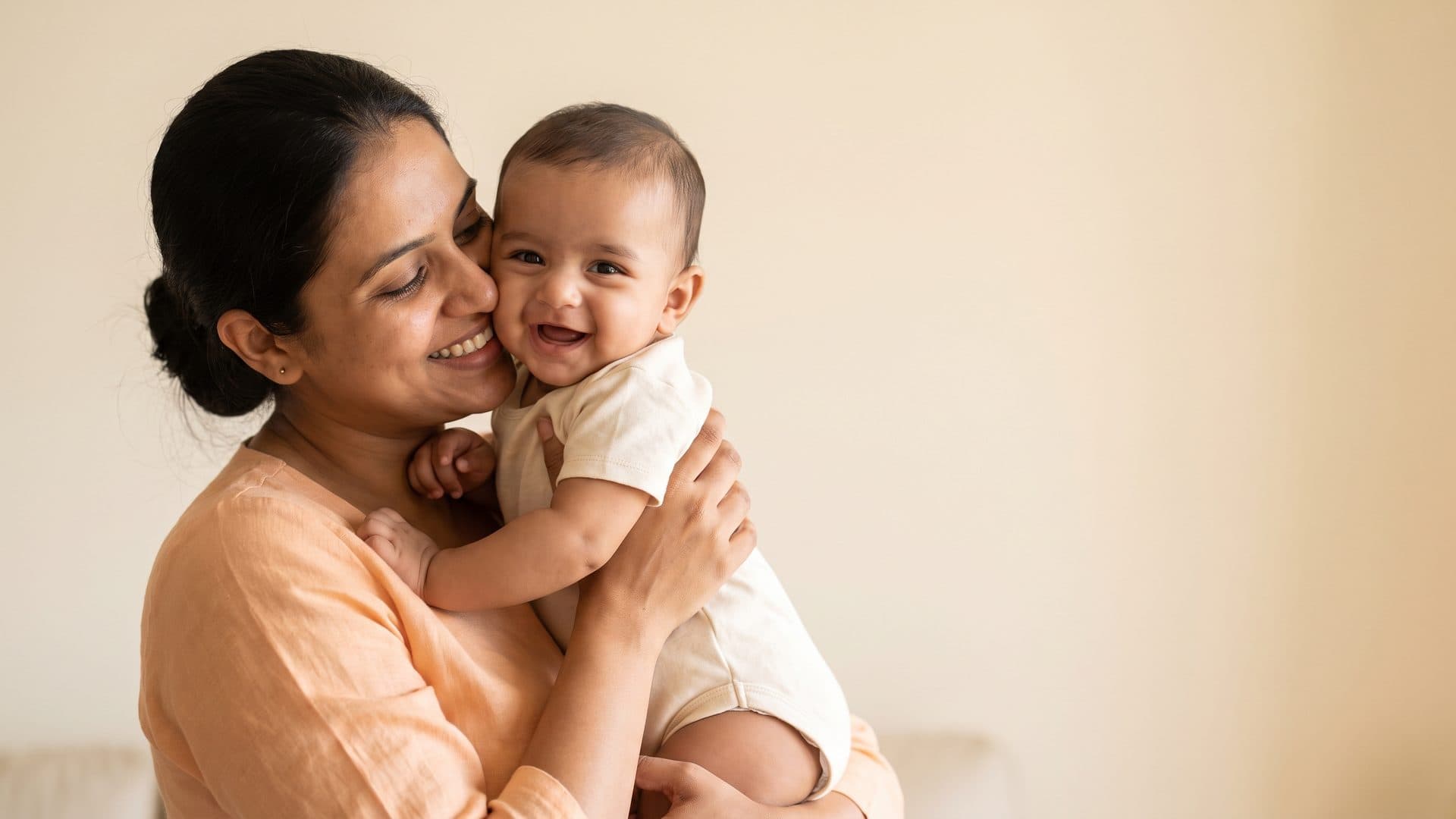 Mother hugging her smiling baby